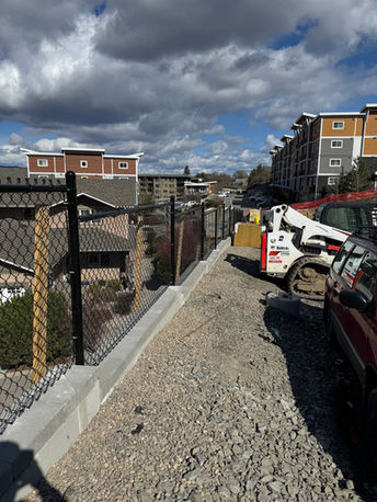 4 foot black chain link fence wall separating new apartment buildings in kelowna bc