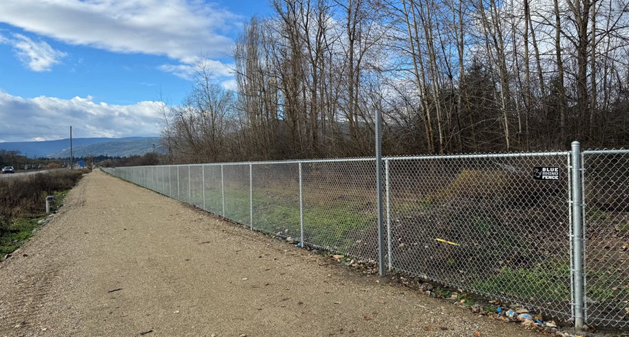 straight lines and uniform design of industrial chain link fence along armstrong rail trail section