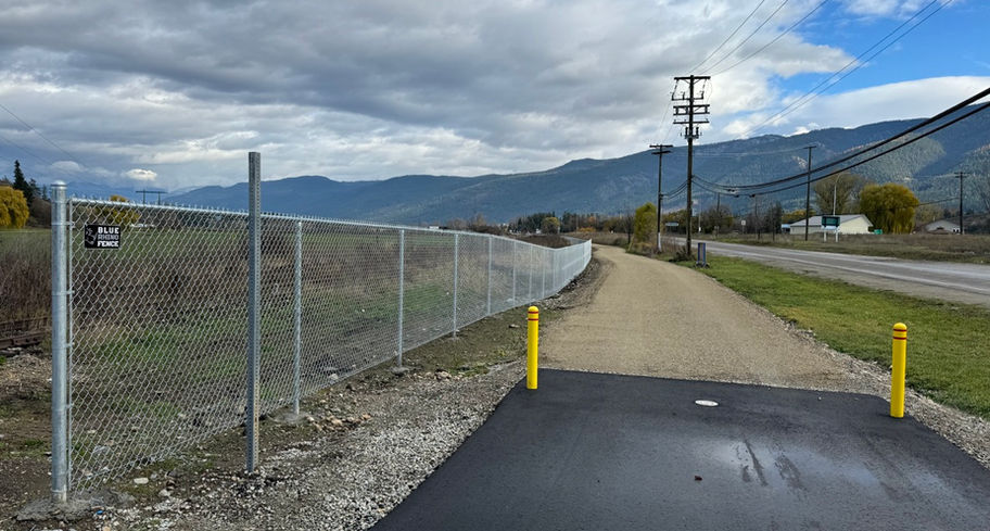 end of pavement view of industrial chain link barrier along the armstrong section of rail trail