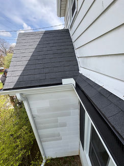 House with black shingles and white siding in a gallery