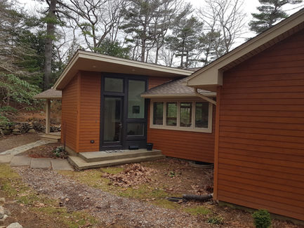 Modern house exterior with orange siding and glass door