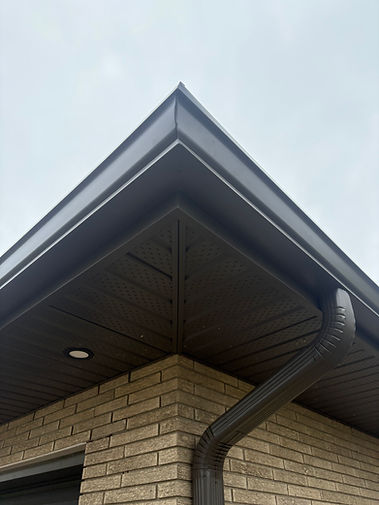 Eavestrough and downspout on a brick house corner.