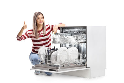 A lady checking her dishwasher for leaks
