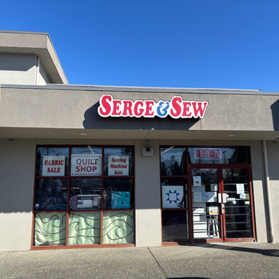 Storefront of Serge & Sew with a 'Fabric Sale' sign