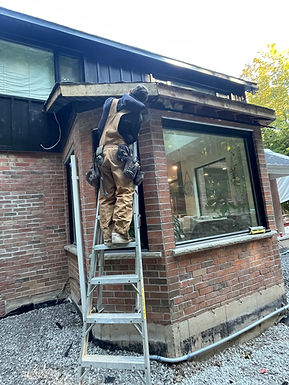 Contractor on a ladder installing soffit and fascia.