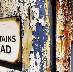 Contains Lead warning sign on peeling blue and white paint