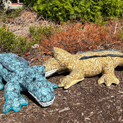 Two patterned plush crocodiles, one blue, one yellow