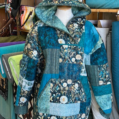 Blue patchwork quilted hooded jacket on mannequin