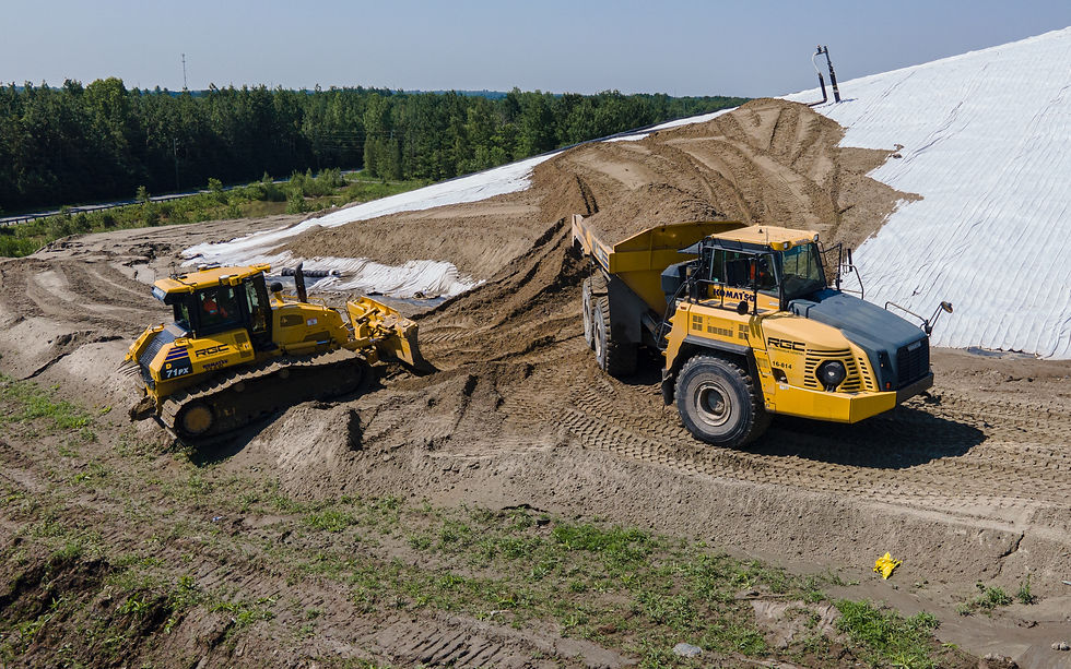 Bulldozer et tombereau articulé déplaçant de la terre sur un chantier.