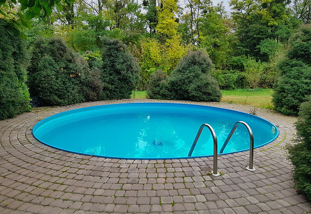 small round home outdoor swimming pool on the plot and overlooking the forest, blue pool,