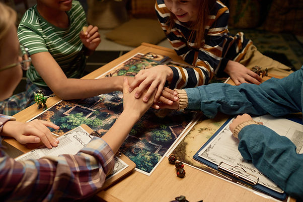 Younger group of friends sitting at the table and playing