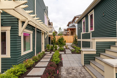 Dark green houses with pathway, stepping stones, and landscaped garden.