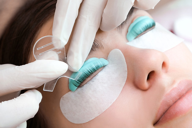 Young woman doing eyelash lamination procedure in a beauty salon