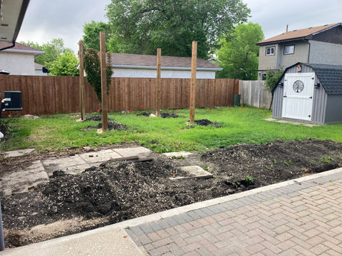 Residential backyard with shed, fence, and construction; Patios & Sidewalks under development.