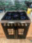 Black gas range with blue flames and oven lights