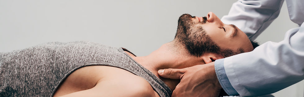 chiropractor massaging neck of man on grey