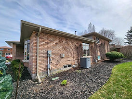 Brick house with clean soffit, fascia, and gutters.