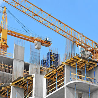 Crane and building construction site against blue sky