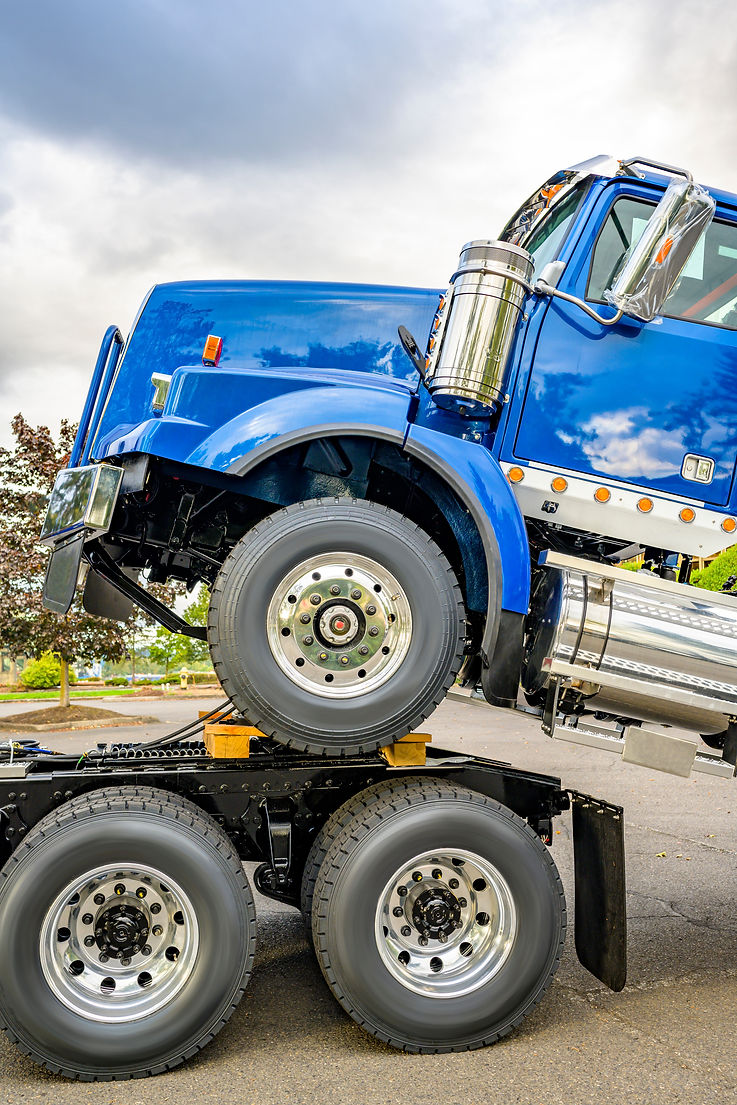 Big rig semi truck towing another blue semi truck tractor on the chassis frame