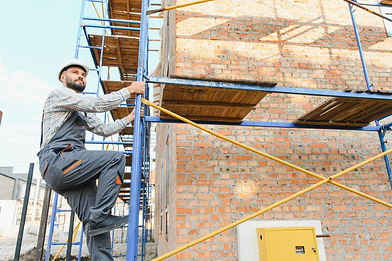 Construction worker using spirit level on brick wall