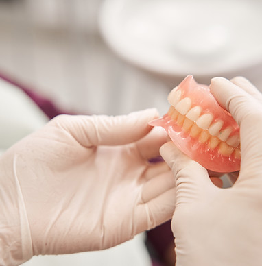 Dentist holding dentures in her hands