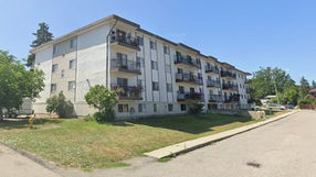 Apartment building with balconies and green lawn