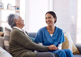 Consulting, caregiver and elderly woman laughing on sofa and holding hands in home living 