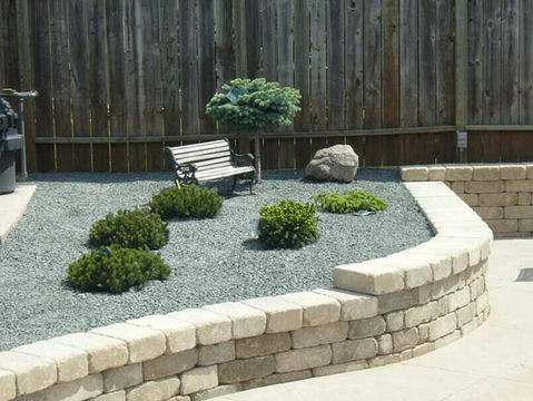 Green bushes and rock garden with Mulch and Decorative Stone in backyard