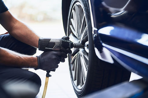 cropped view of mechanic installing new tire on car