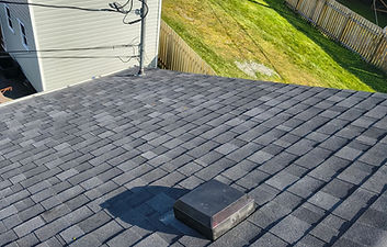 New dark gray shingle roof with square roof vent.