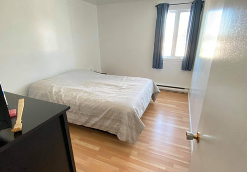 Chambre lumineuse d'un appartement non-meublé avec parquet.