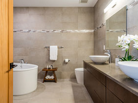 Modern bathroom with a door, sinks and a bathtub. Bathroom Renovation is happening.
