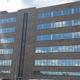 Multi-story brick building with many reflective windows