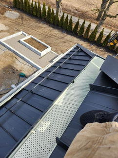 Modern black metal roof with installed snow guards.