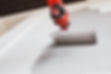Paint roller on the wall during painting