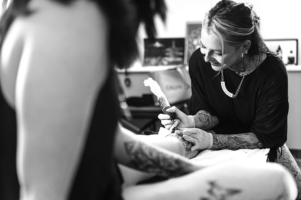 Portrait of a laughing happy woman tattoo master showing a process of creation tattoo on a