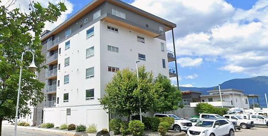 Modern building, parked cars, distant mountains