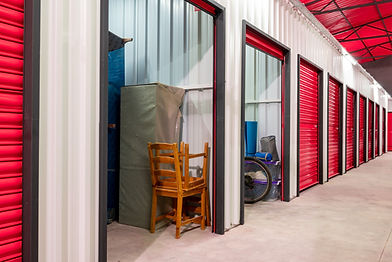 Row of self-storage units with furniture in an open unit.