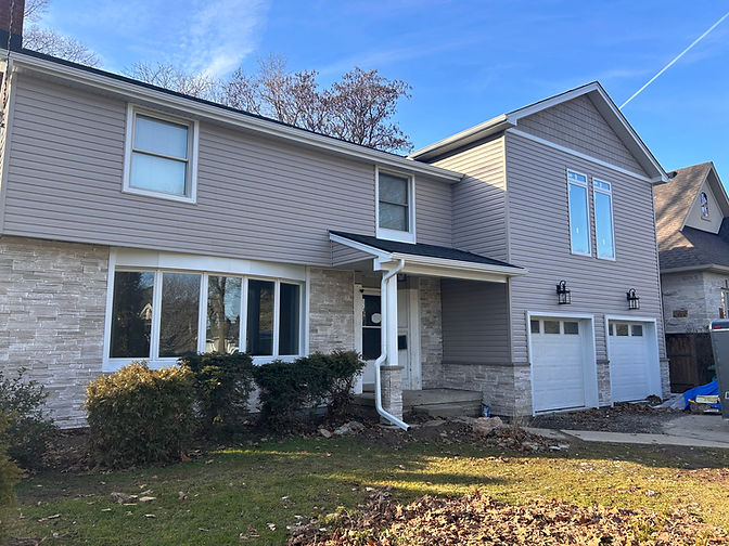 Two-story house with stone and siding exterior.