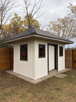 Small white garden shed with a hip roof and dark trim.