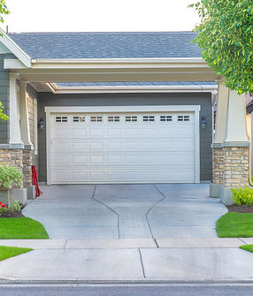 Garage of a house with concrete driveway intersecting with the sidewalk