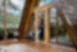 woman stands on the terrace of a wooden bungalow