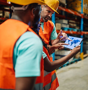 Warehouse workers planning global logistics using digital tablet