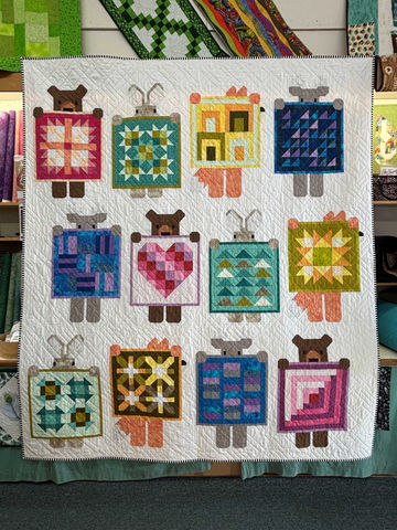 Handmade quilt with 12 colorful bear-like patterned blocks