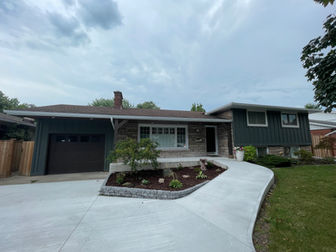 Modern home exterior with concrete driveway and walkway.