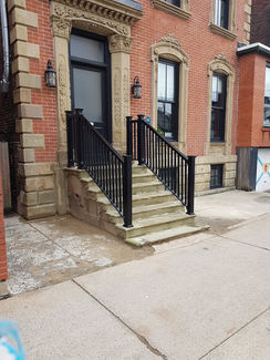 Stone stairs and black railings at building entrance