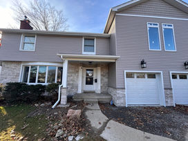 Two-story house with gray siding and stone accents