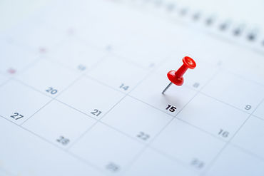 Red pin on the 15th day on the calendar. Business planning concept.