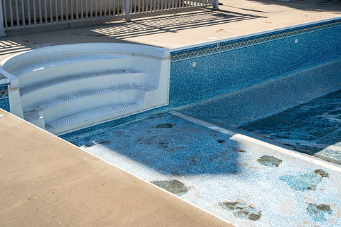 Empty in ground swimming pool ready for replacement of old vinyl lining or liner