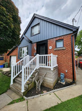 Red brick house with blue siding and white porch railings